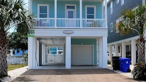 A two-story building with a balcony, a garage, and a sign indicating a private parking area. - Ohana - Walk to beach in Surfside Beach (Surfside Beach)