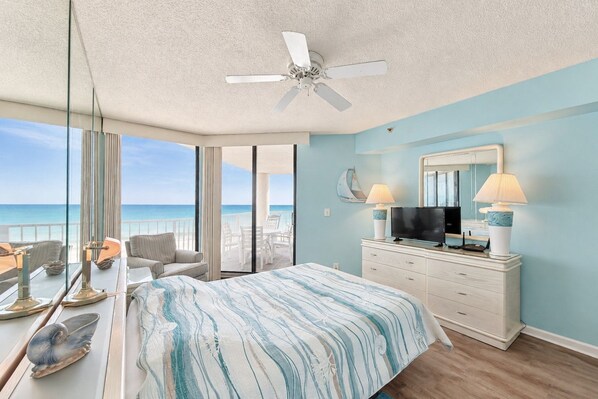 A bedroom with a bed, a TV, a dresser, and a balcony with a view of the ocean. - One Ocean Place 505 - Oceanfront in Garden City Beach (Garden City)