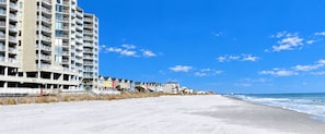 A beachfront hotel with multiple floors, a sandy beach, and a clear blue sky. - One Ocean Place 505 - Oceanfront in Garden City Beach (Garden City)