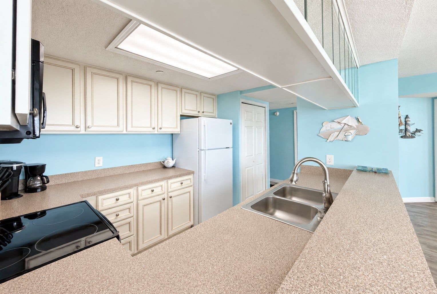 A modern kitchen with a built-in oven, a refrigerator, and a sink.