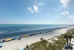 A beach with umbrellas, chairs, and a clear sky. - One Ocean Place 505 - Oceanfront in Garden City Beach (Garden City)