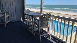 A balcony with a view of the beach and a pool. - Mariner's Watch 204 - Oceanfront in Garden City Beach (Garden City)