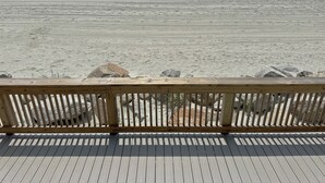 Eine Holzterrasse mit Blick auf den Strand.