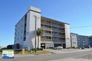 Un immeuble à plusieurs étages doté d’une entrée centrale et de balcons.