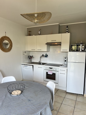 A modern kitchen with white cabinets, a built-in oven, a microwave, and a dishwasher. - Charming duplex and charming residence in Hardelot ideally located (Neufchâtel-Hardelot)
