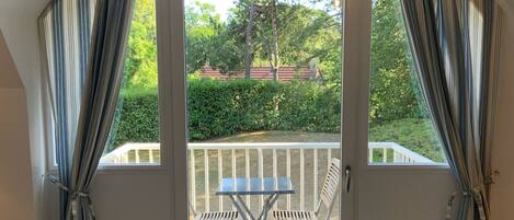 A room with a sliding glass door leading to an outdoor patio with a table and chairs.