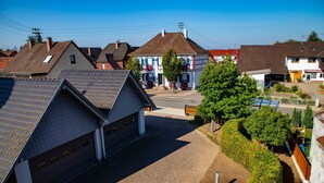 A residential area with houses, a garage, and a well-maintained lawn. - FeWo Studenik (Neuried)