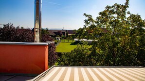 A rooftop terrace with a clear view of a green lawn and buildings in the distance. - FeWo Studenik (Neuried)