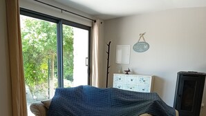 A living room with a beige sofa, a wooden coffee table, and a blue blanket.