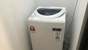 Lavadora blanca de tamaño compacto, con varios botones de control y etiqueta de eficiencia energética.