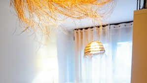 A dining area with a table set for four, including plates, cups, and a candle. - Apartamentos Costa Norte (San Vicente de la Barquera)