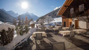 A wooden chalet with outdoor seating and a mountain view. - Gasthof Gröbenhof (Fulpmes)