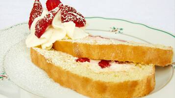 A slice of cake with whipped cream and strawberries on a plate.