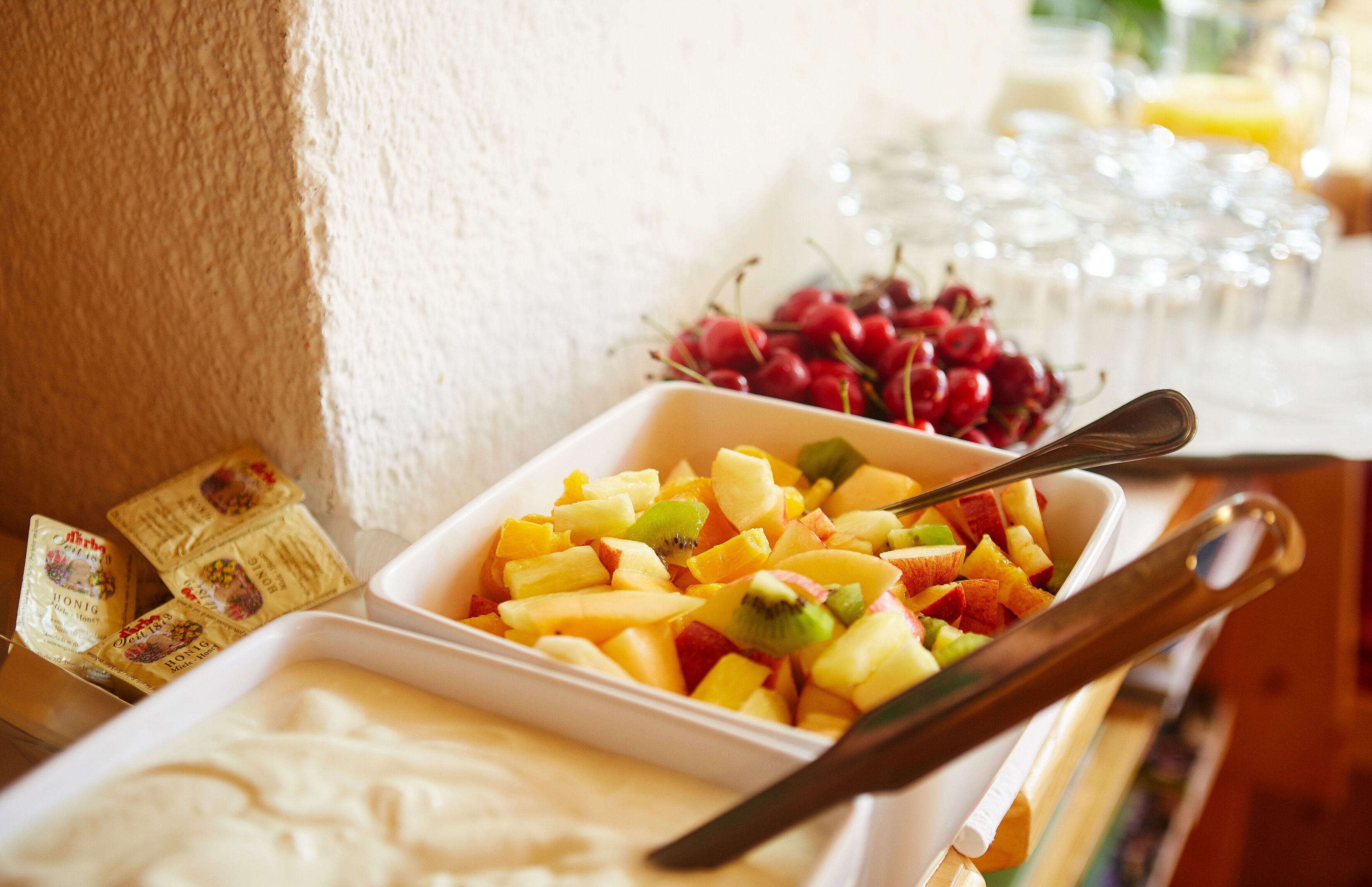 Une table de buffet garnie d’une variété de fruits et accompagnée d’une cuillère.