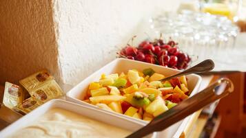 Une table de buffet garnie d’une variété de fruits et accompagnée d’une cuillère.