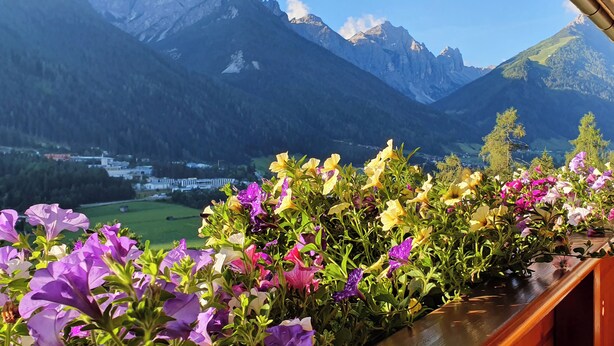 A balcony with a view of mountains and a town below. - Gasthof Gröbenhof (Fulpmes)