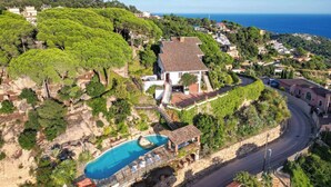 A villa with a swimming pool, surrounded by lush greenery and overlooking a coastal area. - Panoramic Sea View and Private Pool (Lloret de Mar)