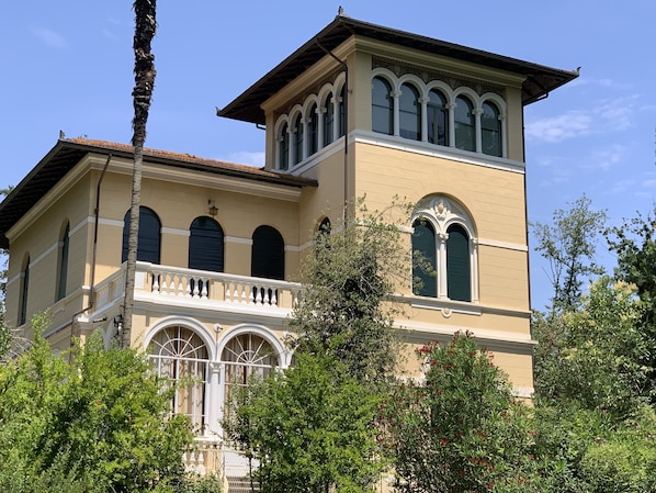 A two-story building with a balcony and arched windows.