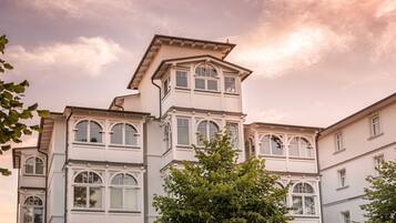 A multi-story building with a prominent corner section and multiple windows.