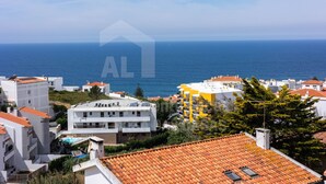 Un pueblo costero con edificios blancos y tejados de tejas rojas, con vistas al mar.
