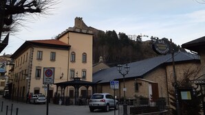 A street view with a building that has a tower, a sign for a bar and restaurant, and a no parking sign. - B&B Casa Mucci (Sestola)