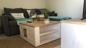 Ein modernes Wohnzimmer mit einer Couch, einem Couchtisch und einem kleinen Schrank.