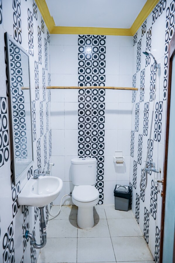 Un baño con inodoro, lavamanos y espejo.