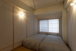 A bedroom with a large window, a bed with two pillows, and a wall-mounted light. - 2254 Gion Miyagawacho Capacity 5 people / Kyoto Kyōto (Kyoto)