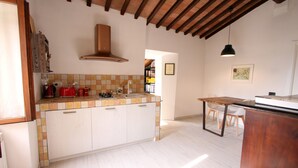 A kitchen with white cabinets, a tiled backsplash, and a wooden ceiling.