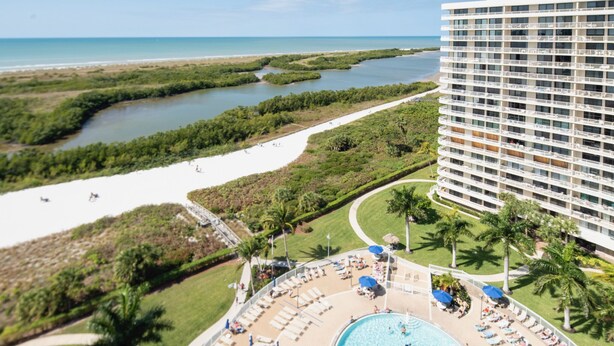 Ein Resort mit großem Pool, Strandbereich und Blick auf den Ozean.