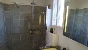 Un baño moderno con ducha, inodoro y lavamanos.