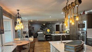 A spacious kitchen with a central island, modern appliances, and a rustic chandelier. - Lakefront property with pool and lighthouse with amazing views of the lake, . (Granbury)