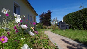 A pathway leading to a house with a garden full of flowers. - Holiday house with large garden and wonderful view (Weinsfeld)