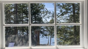 A window with a view of trees and a body of water. - 10+ Spacious Cape on Winnipesaukee Island. Private Peninsula. Sunset Views. (Meredith)