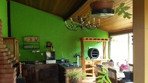 Eine Küche mit grüner Wand, Holzboden und einer hängenden Pflanze.