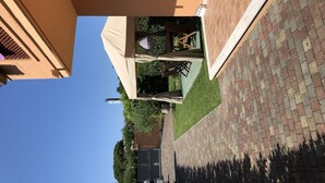 A patio area with outdoor furniture, a covered seating area, and a brick pathway. - B&B Il Viaggiatore (Massa)