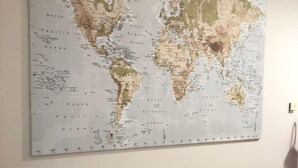 A world map on a wall with a wooden bench below. - B&B Il Viaggiatore (Massa)