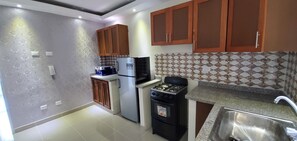 Enjoy cooking in this well-equipped kitchen with a refrigerator, gas stove, and microwave.