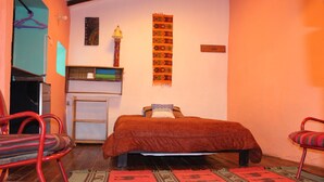 A room with a bed, a desk, a chair, and a hanging tapestry. - Moutainbike House (Calca)