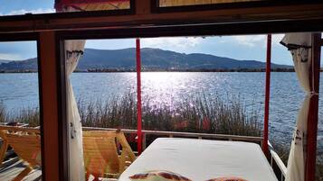 Une chambre avec vue sur un lac et des montagnes.