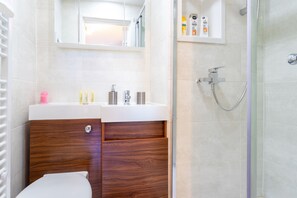 Enjoy a clean and contemporary bathroom with a sleek vanity and glass-enclosed shower area.