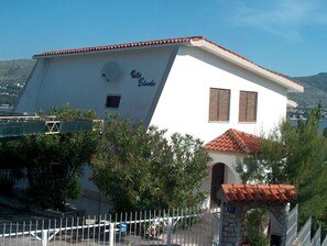 A white building with a red-tiled roof, a satellite dish, and a sign reading "Villa Blanca." - Guest House Blanka (Okrug)