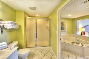 A bathroom with a toilet, sink, and a walk-in shower.