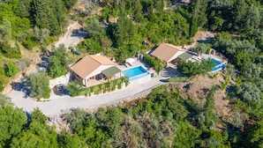 An aerial view of a property with two buildings, a swimming pool, and a driveway. - Melissi Villa, overlooking Vasiliki bay, close to the beach and other amenities! (Lefkada)