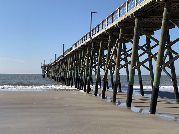 A pier extending into the ocean with a clear sky. - ~Carolina Tides~ Ocean View, Pier, Pool, Steps to the Beach and Restaurants! (Oak Island)