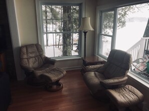 Una habitación con dos sillones de cuero, una mesa de centro de madera y una lámpara de pie.