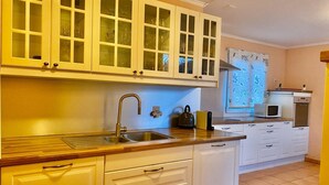 A kitchen with white cabinets, a stainless steel sink, and a microwave. - Amazing Villa Littau  (Luzern)