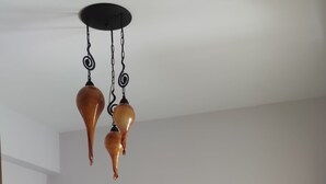Ein ordentlich bezogenes Bett mit weißen Leinen, einem Holzkopfstück und einem Nachttisch mit einer Vase.