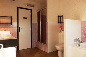 Et badeværelse med toilet, vask og badekar.