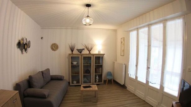 A living room with a sofa, a wooden coffee table, a cabinet, and a television. - Near Royan, 96m2 house with 500m2 enclosed garden - 3 beaches within 600m (Vaux-sur-Mer)